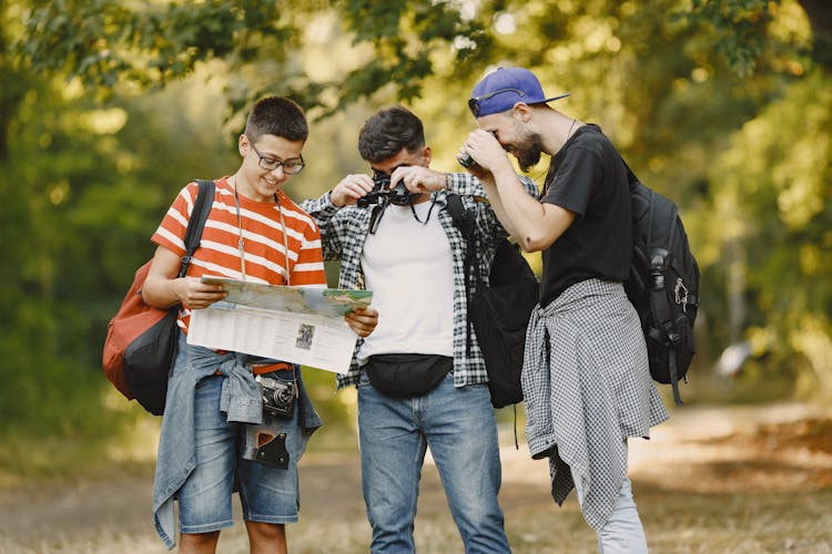 Three Young Hikers Looking At Map