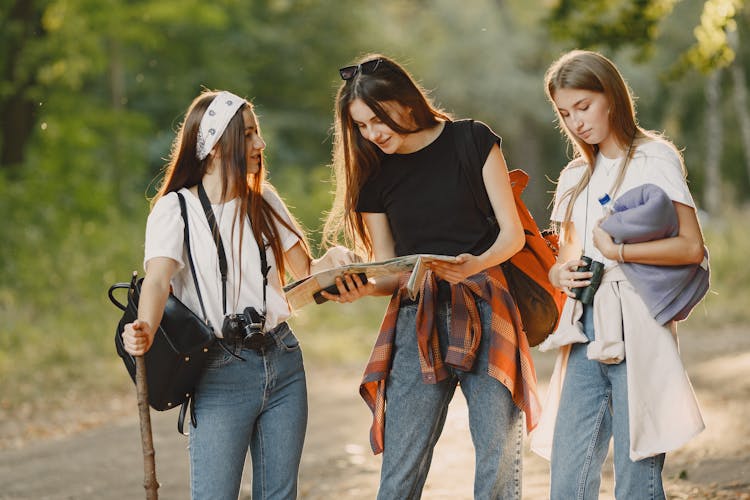 Girlfriends With Map Walking In Forest