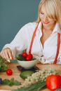 Woman in White Button Up Long Sleeve Shirt Holding Red Tomato