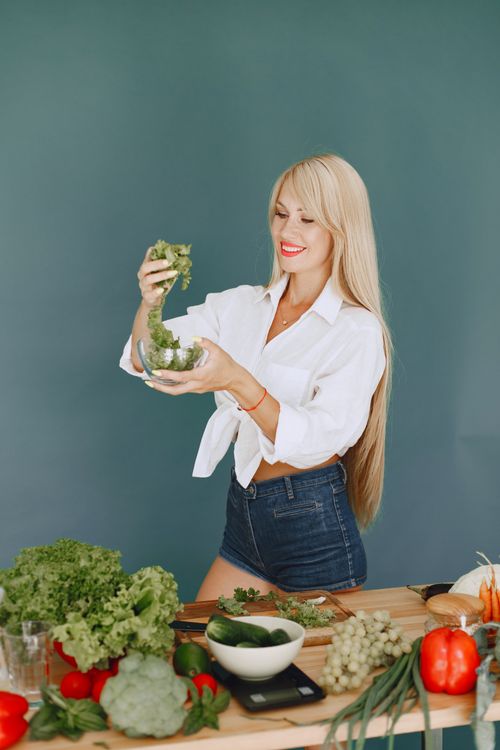 Free Woman preparing fresh vegetables at home for a healthy meal. Stock Photo