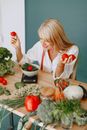 Woman in White Long Sleeve Shirt Holding Red Apple Fruit