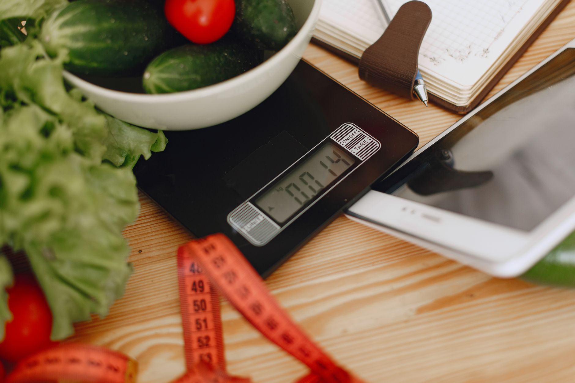 meal prep ideas for weight loss beginners - A bowl of fresh vegetables on a kitchen scale with measurement tools, depicting a