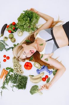 A woman enjoying a healthy lifestyle with fresh vegetables and fitness equipment, promoting wellness.