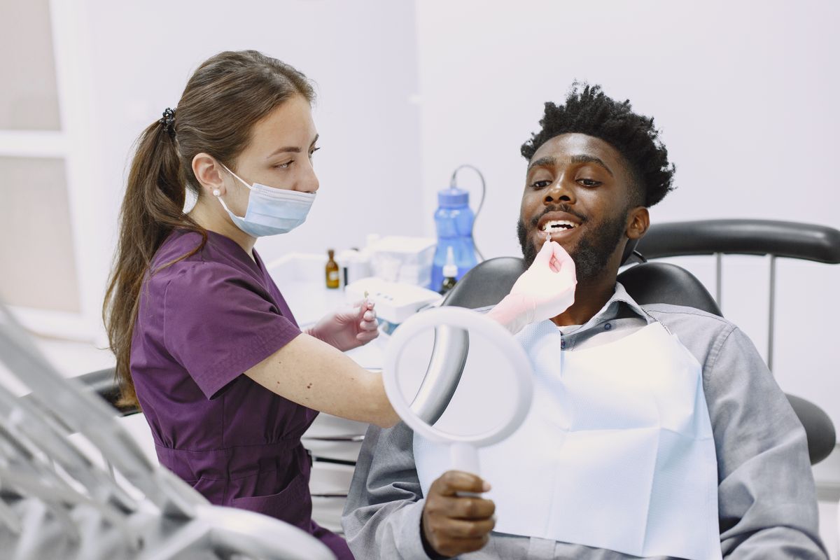 Dentista orientando paciente durante consulta odontológica
