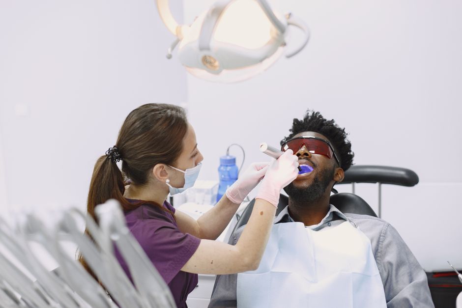 A dental hygienist performing a professional cleaning on a patient - scaling and polishing A dental hygienist performing a professional cleaning on a patient - scaling and polishing