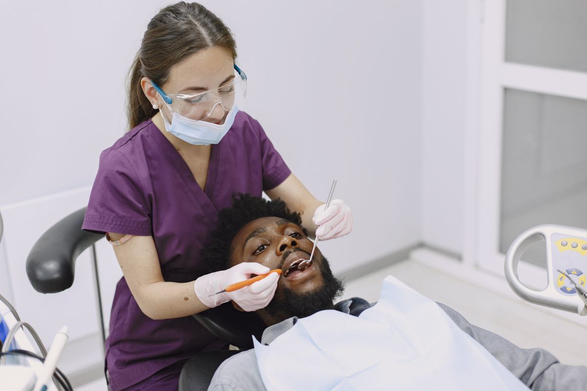 Dentista profesional atendiendo a paciente en clínica dental moderna