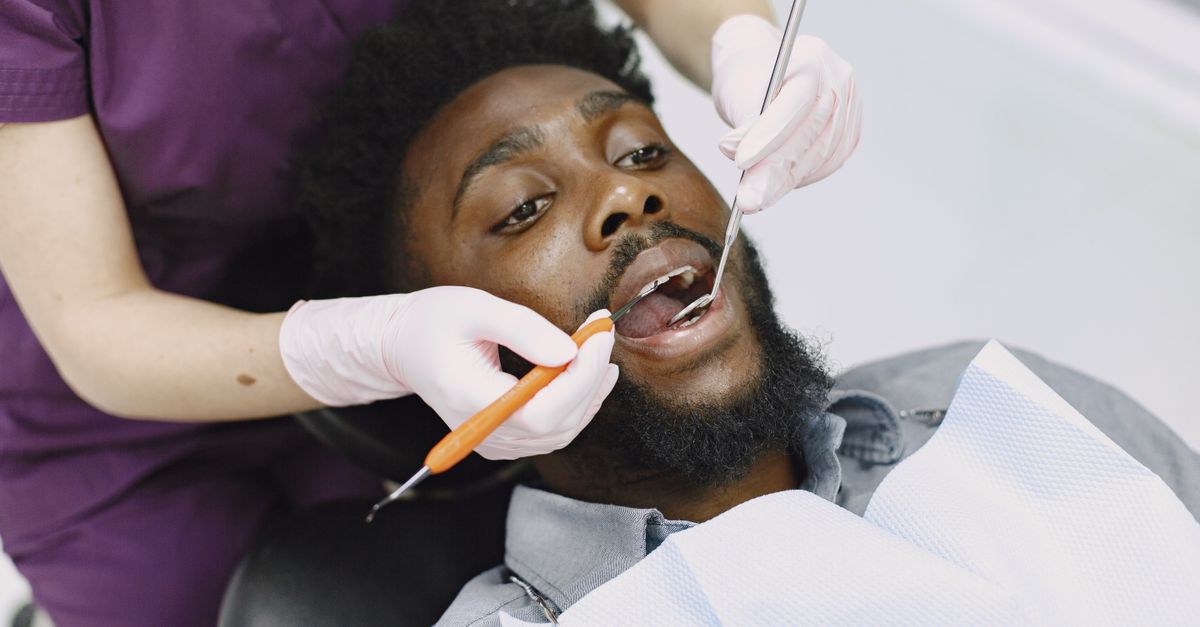 Dentist examining a man's teeth during a routine checkup