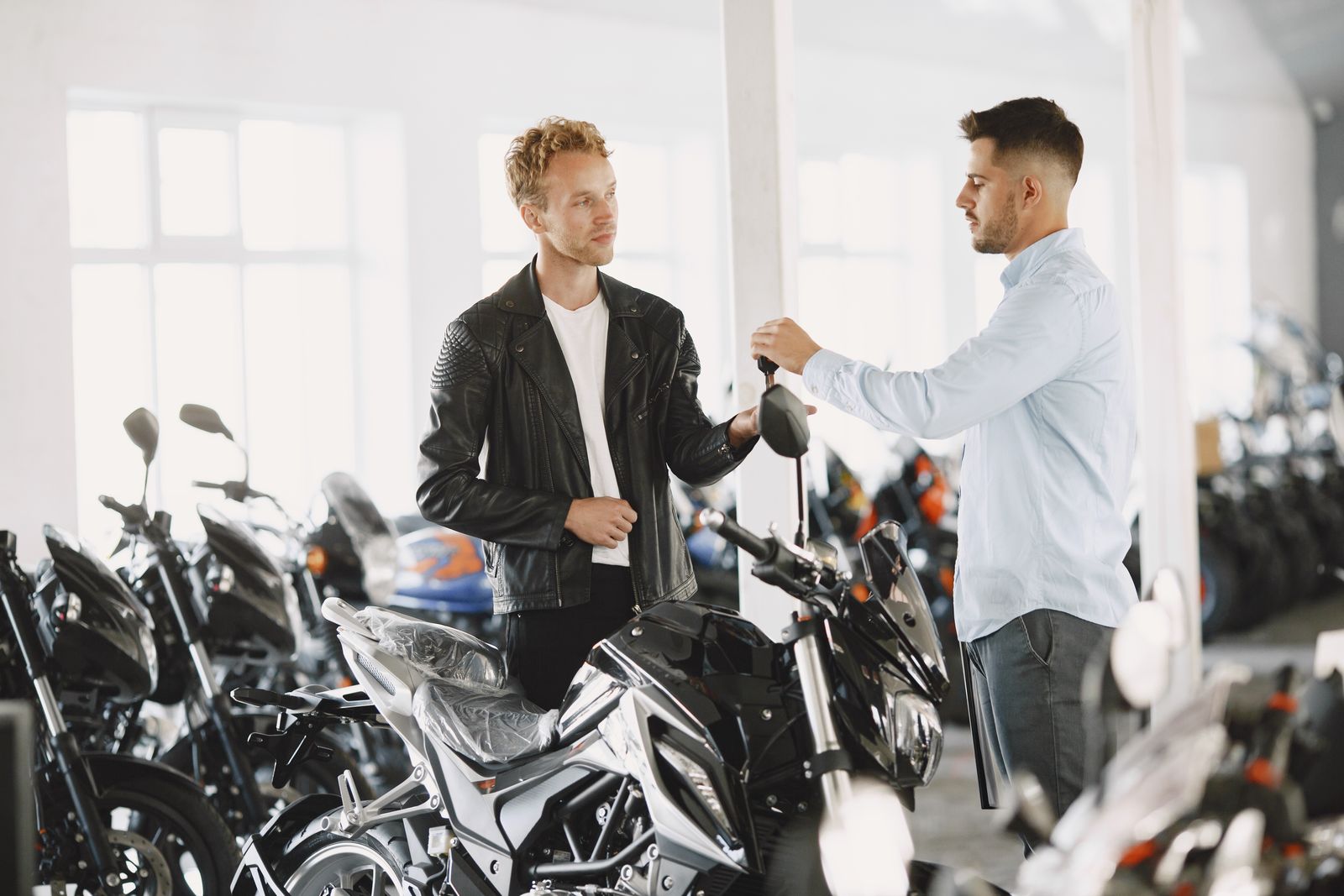 Deux personnes discutant dans un showroom de motos