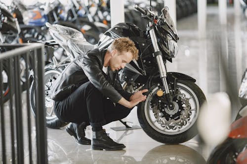 Man in Black Leather Jacket Kissing Woman in Black Leather Jacket on Black Motorcycle