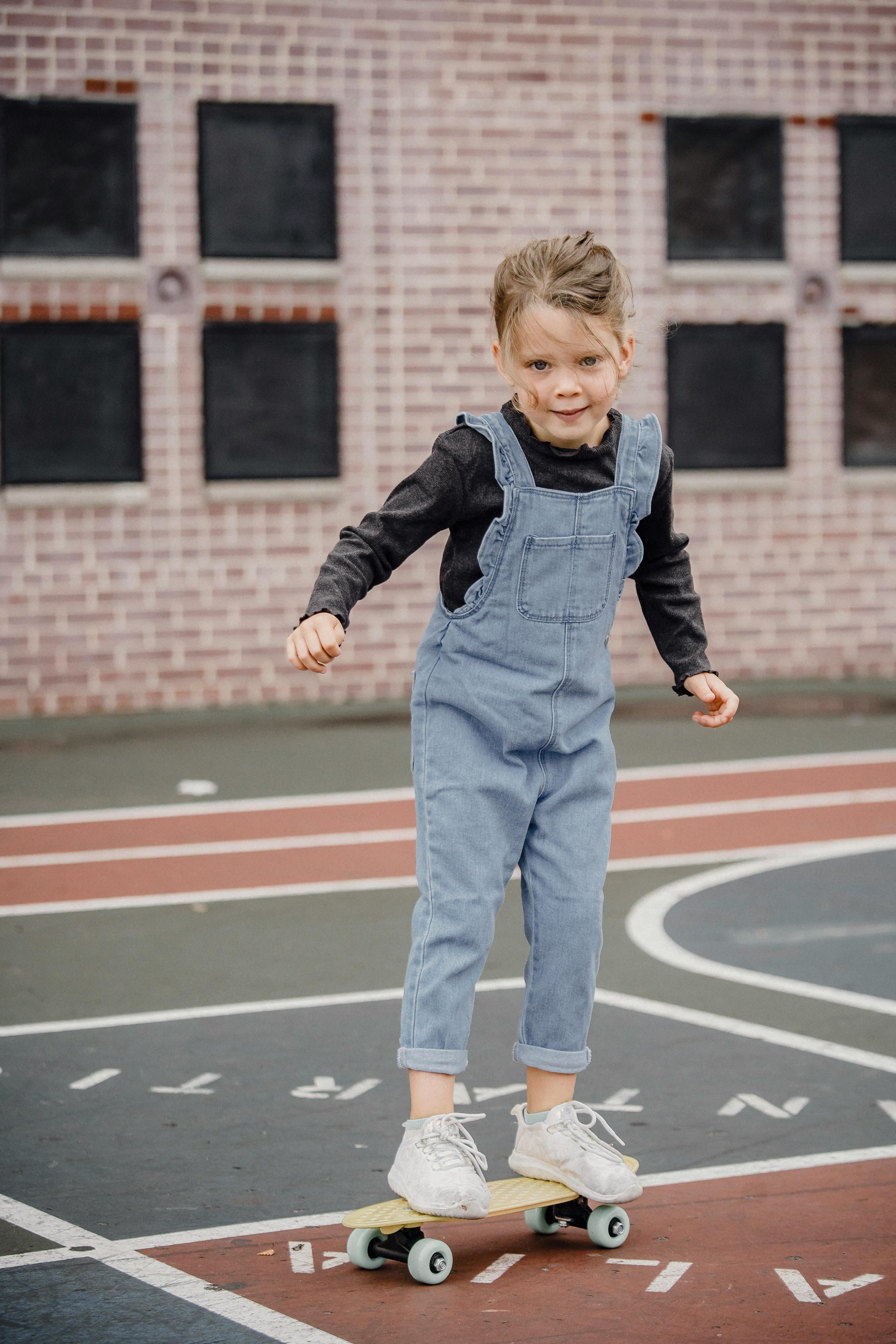 cheerful little girl riding penny board