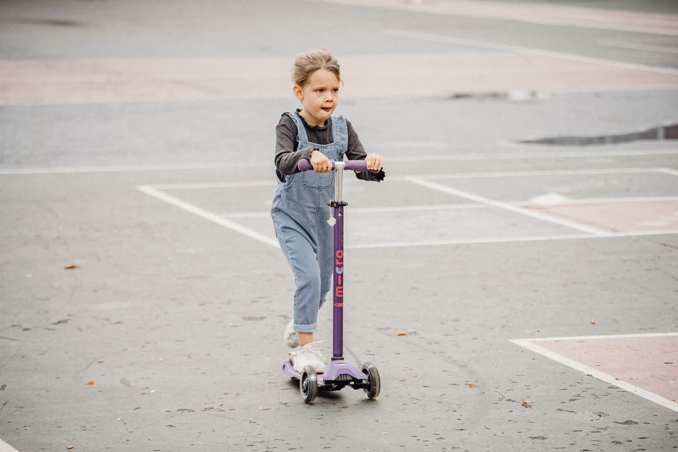 Niña usando patinete en el parque