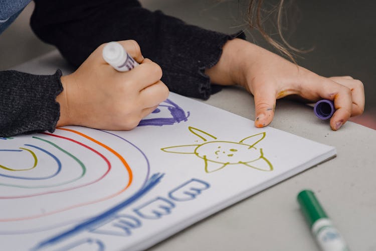 Crop Child Drawing Rainbow And Sun