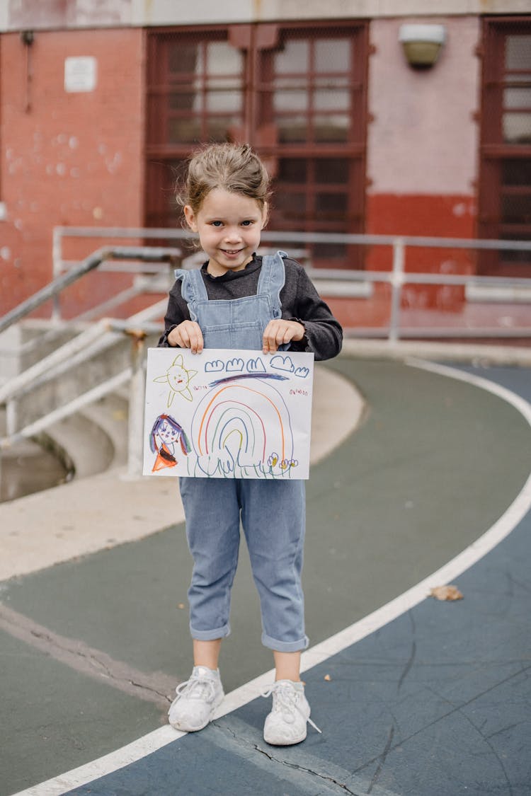 Cute Girl With Drawing In Hands