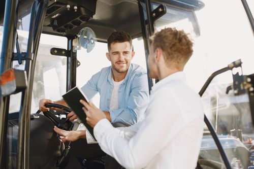 Free Two men collaboratively discussing inside machinery cabin, fostering teamwork. Stock Photo