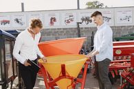 Man in White Dress Shirt and Black Pants Holding Red Plastic Container