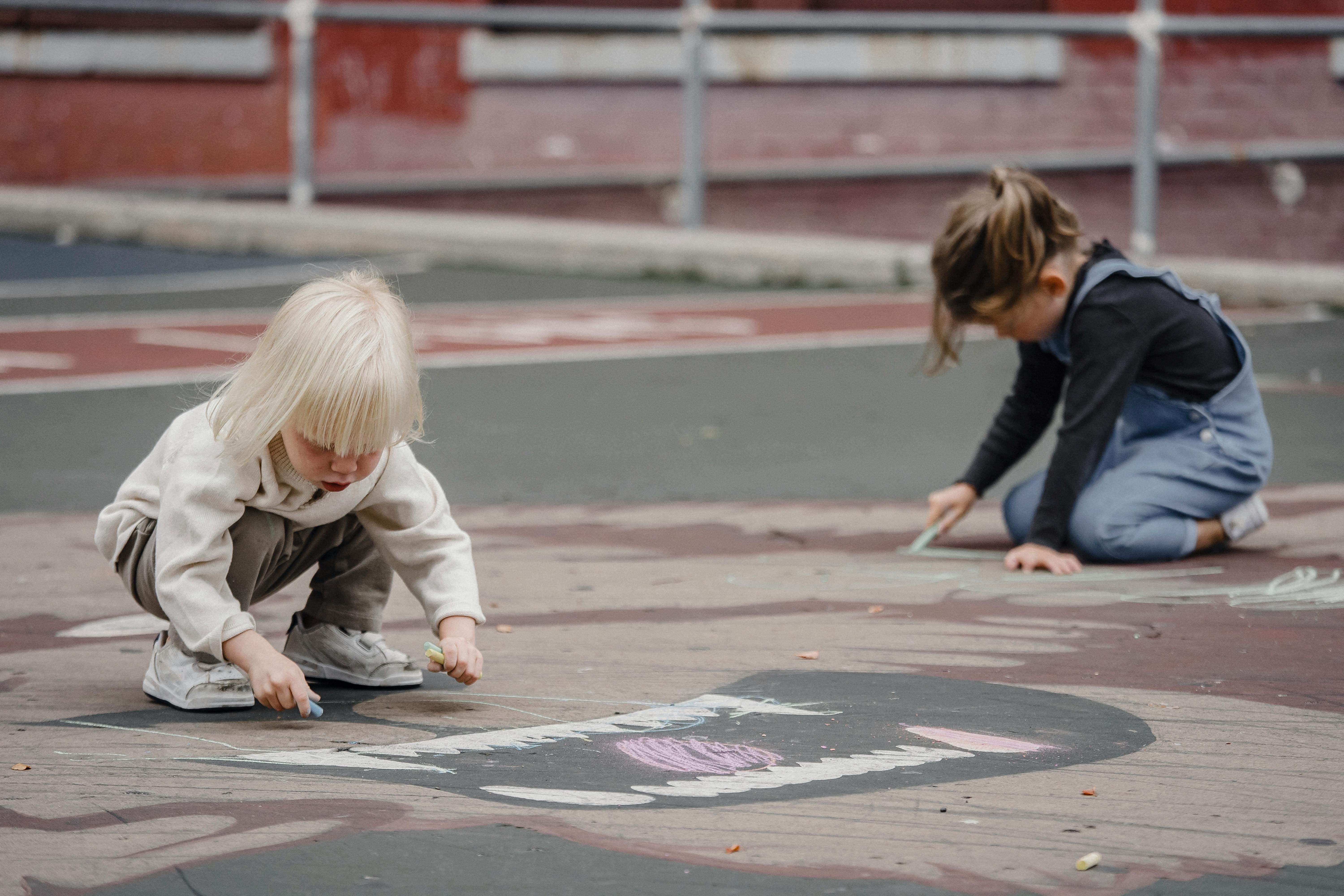 unrecognizable children drawing with chalks