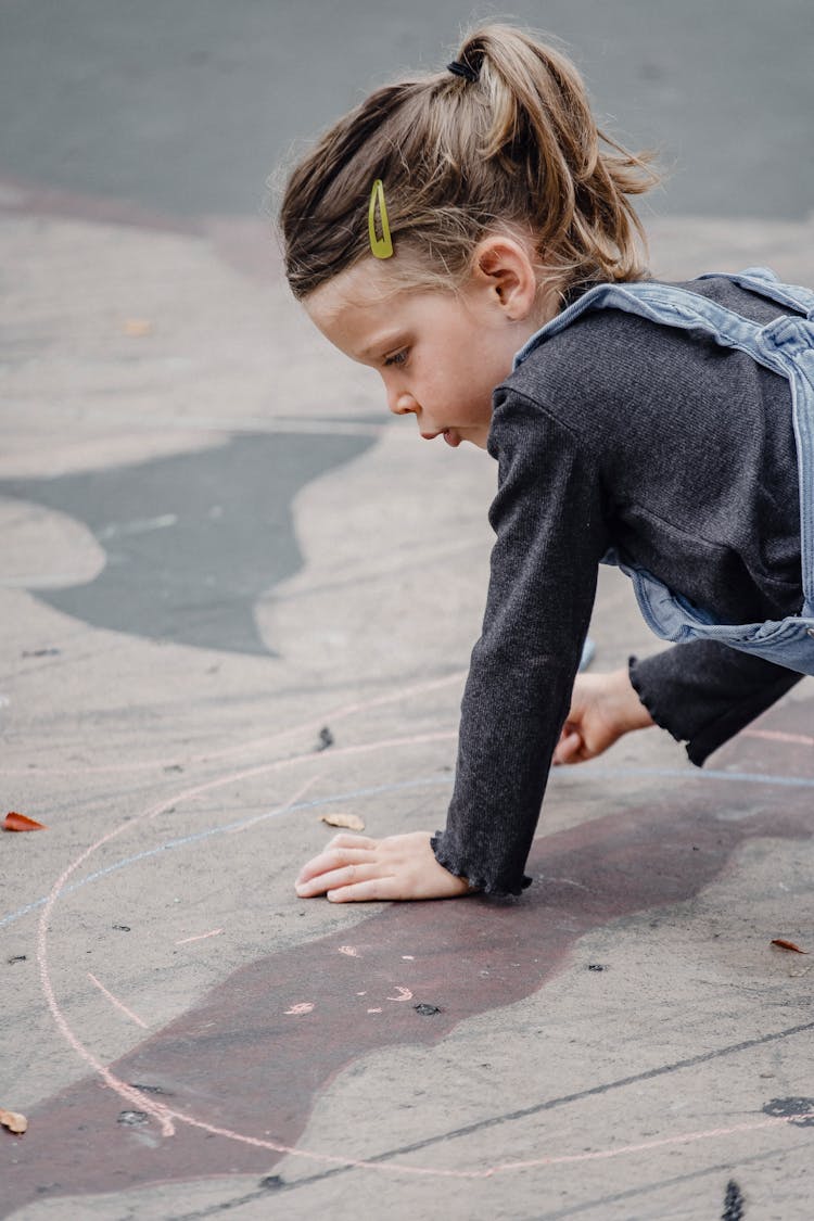 Little Girl Drawing Circle With Chalk