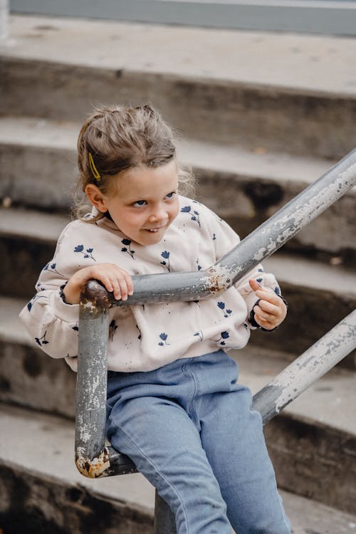 Little girl sitting on railing