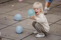 Excited girl with colorful balloons