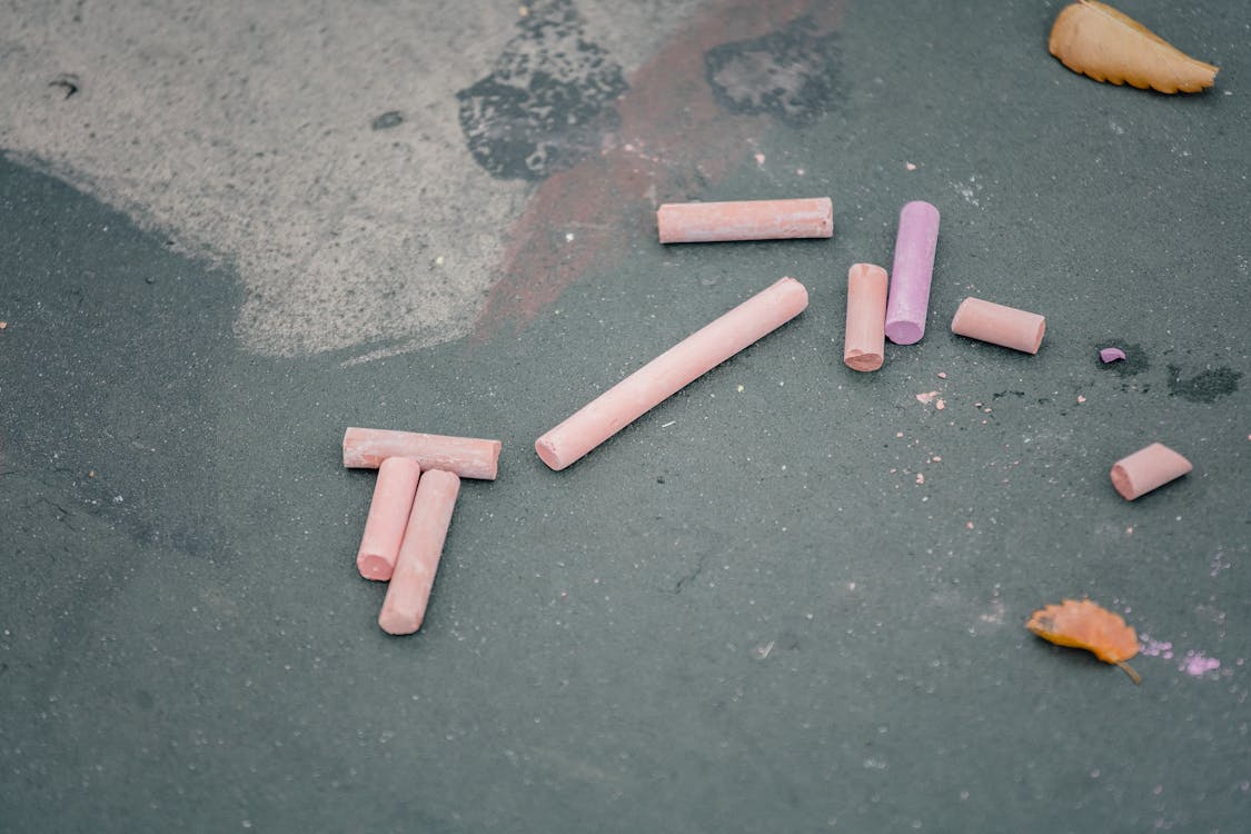 Pink chalks placed on gray asphalt