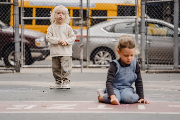 Kids With Chalks Spending Time On Sidewalk