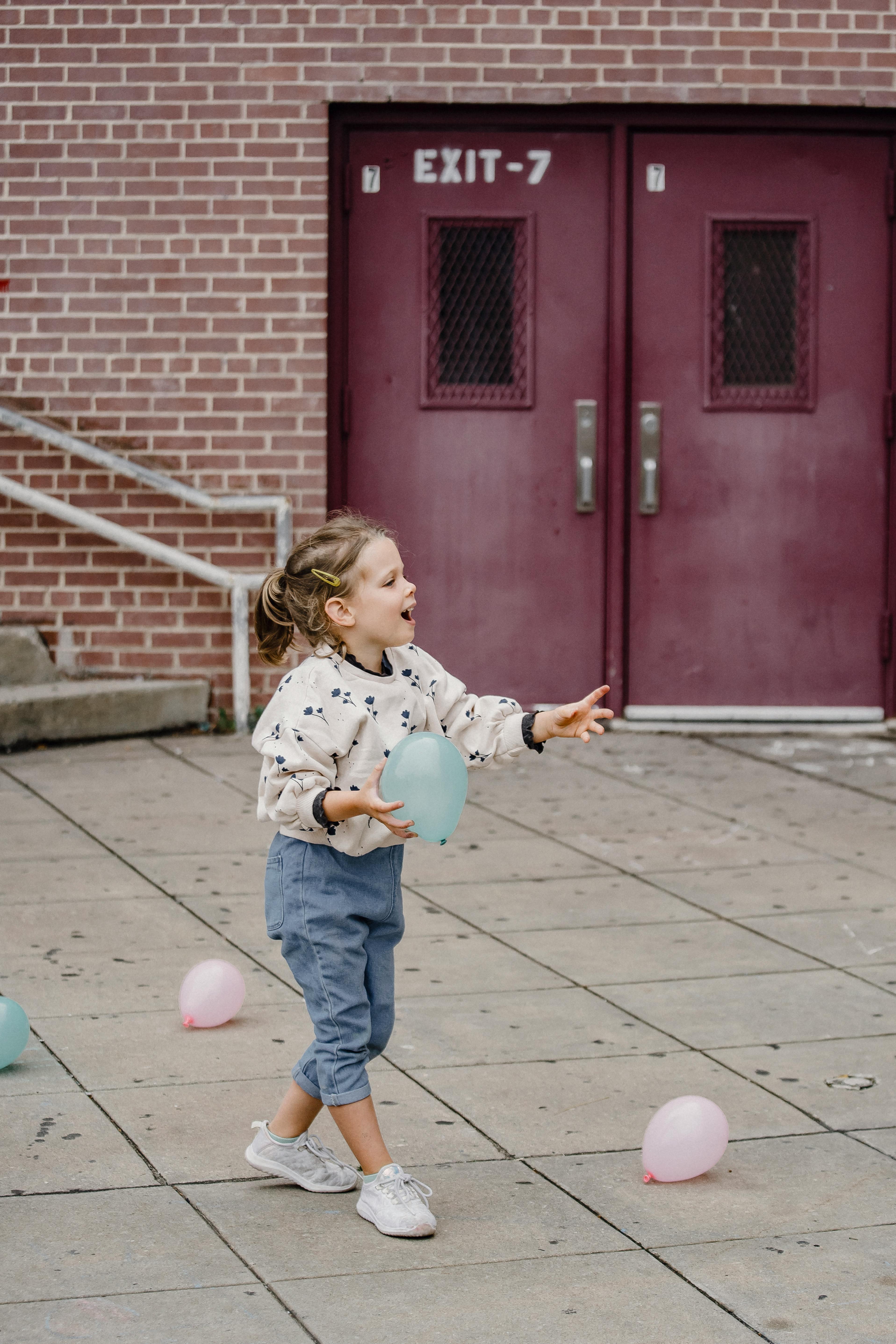 happy girl having fun with balloons on city street