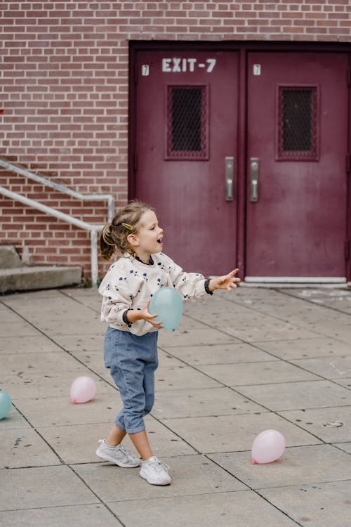 Happy girl having fun with balloons on city street