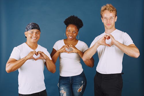 Three People Smiling at Camera While Doing a Heart Sign