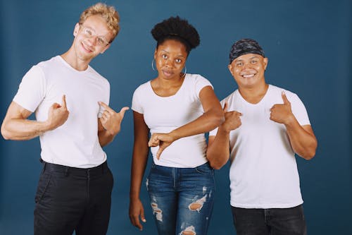 Three People Doing Hand Gestures While Smiling at Camera