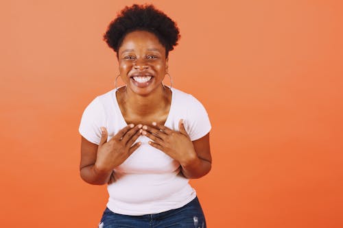 A Smiling Woman in White Crew Neck T-shirt and Blue Denim Bottoms