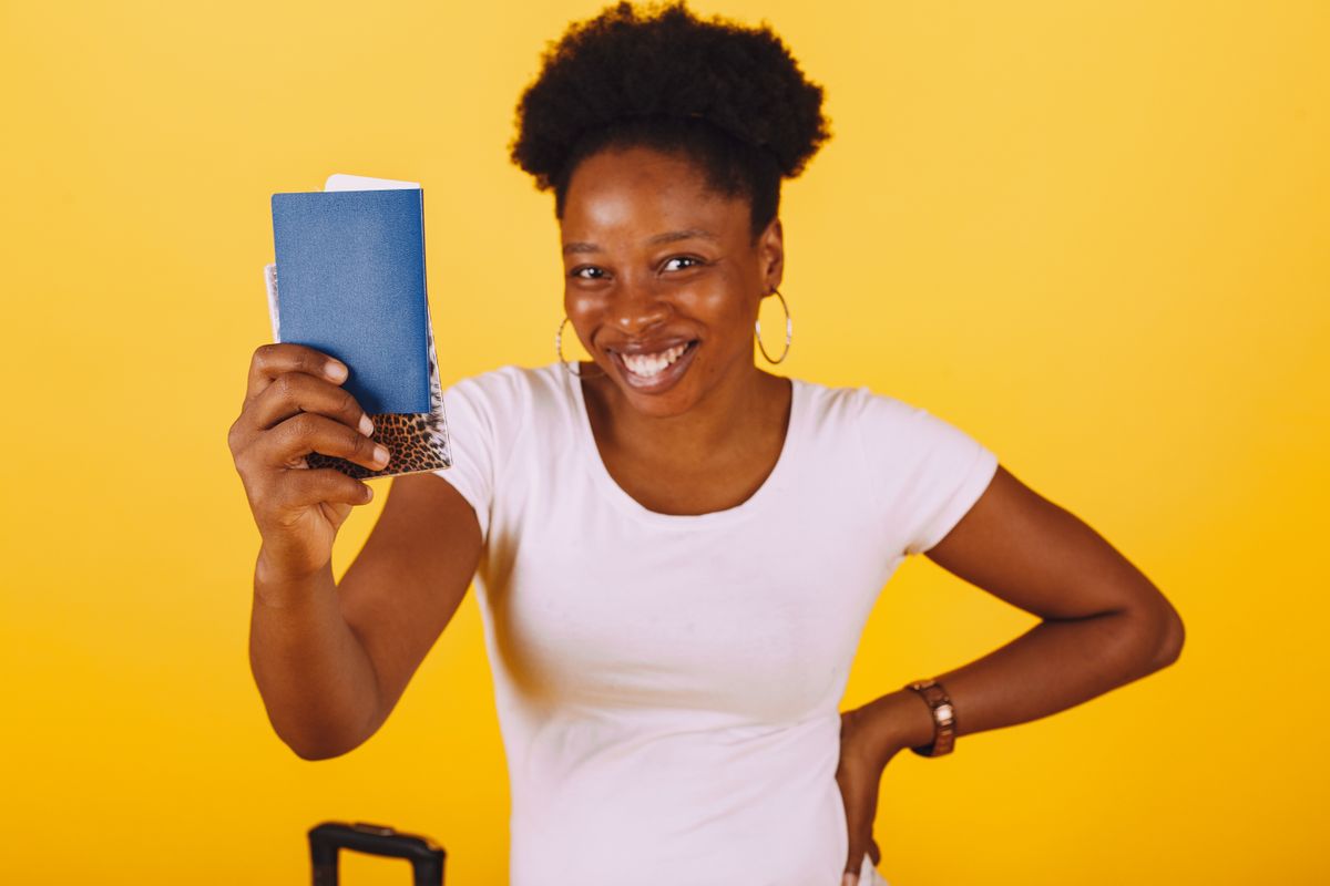 Trucos de viajera experta: mujer sonriente lista para viajar con su pasaporte