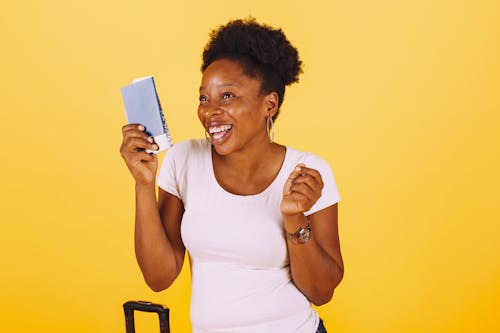 Free Smiling Woman in White Shirt Holding Her Passport Stock Photo