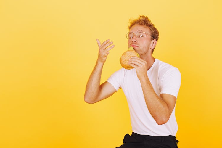 Man In White Shirt Smelling The Delicious Burger