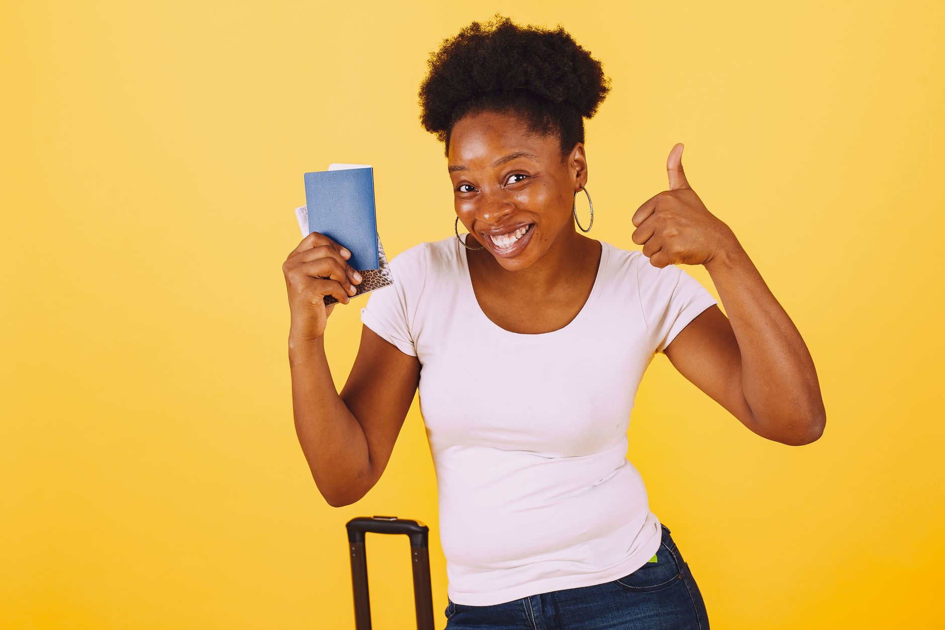 Campus France Application Guide for International Students 2 Smiling woman holding passport giving thumbs up against yellow background.