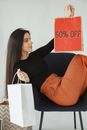 Woman with Shopping Bags Sitting on Chair 
