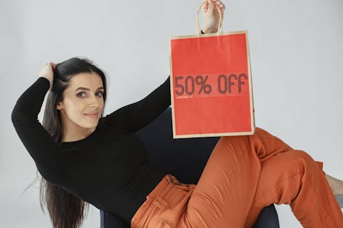 Free Woman seated in an Armchair carrying a Shopping Bag  Stock Photo