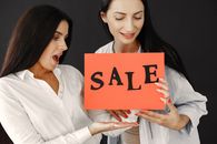 Women Holding a Sign with Sale Written on It 