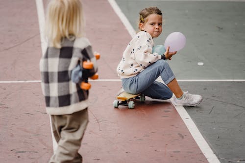 Unrecognizable girl with best friend on skateboard in town