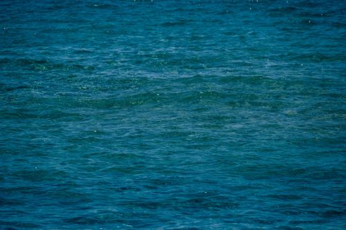 Free From above of surface of wavy blue sea on sunny day as background Stock Photo