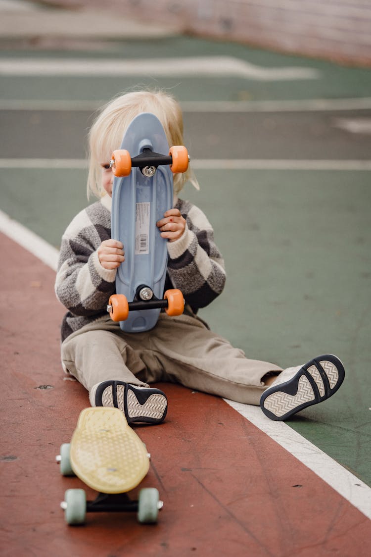 Anonymous Little Kid With Penny Board On Playground