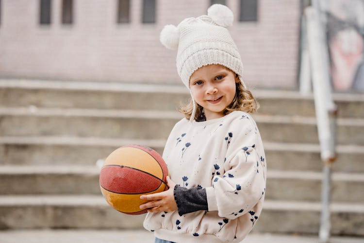 Cute Girl With Ball On Street