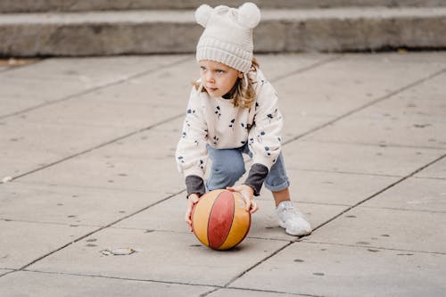 Girl playing with ball on street