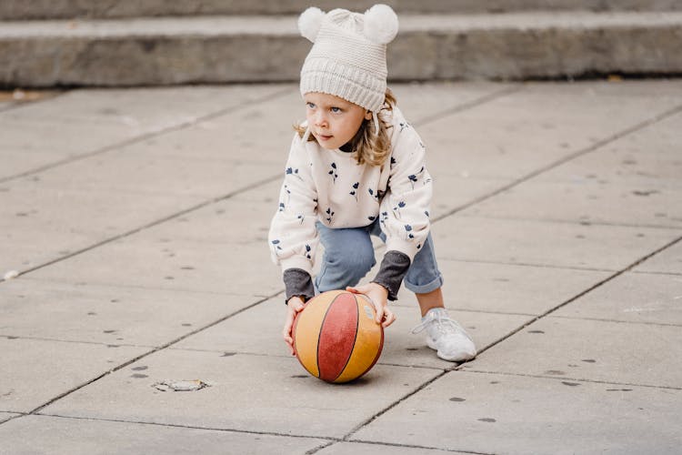 Girl Playing With Ball On Street