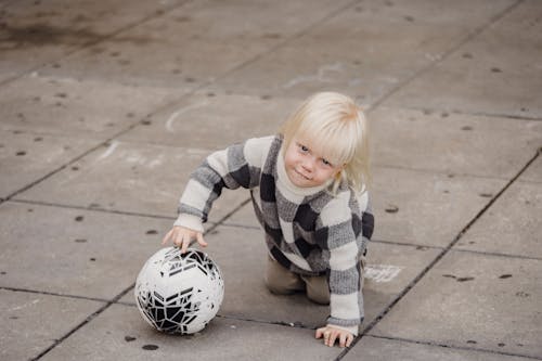 Ragazza In Camicia A Maniche Lunghe A Righe Bianche E Nere Che Giocano A Calcio