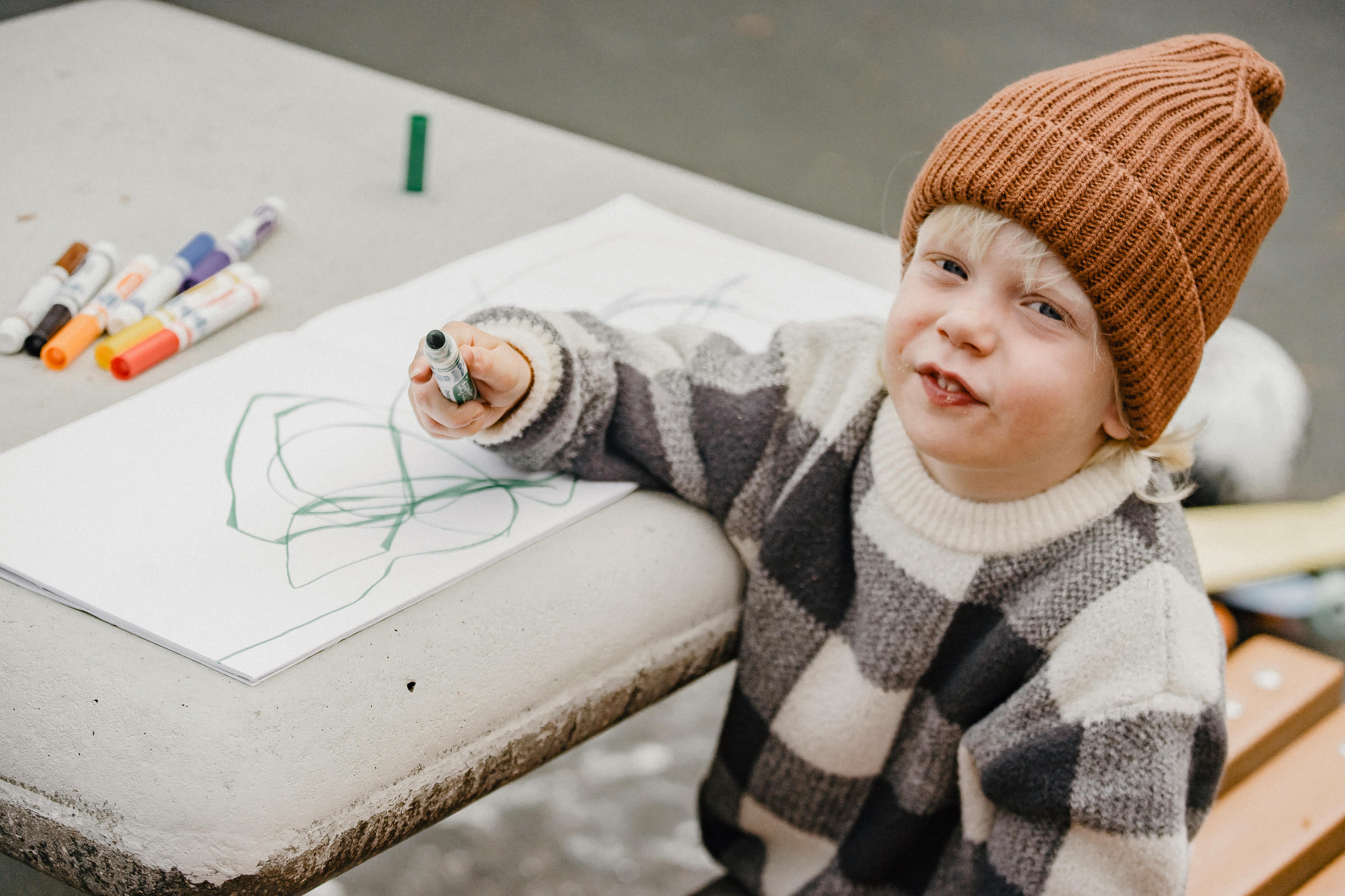 little child drawing messy picture in album