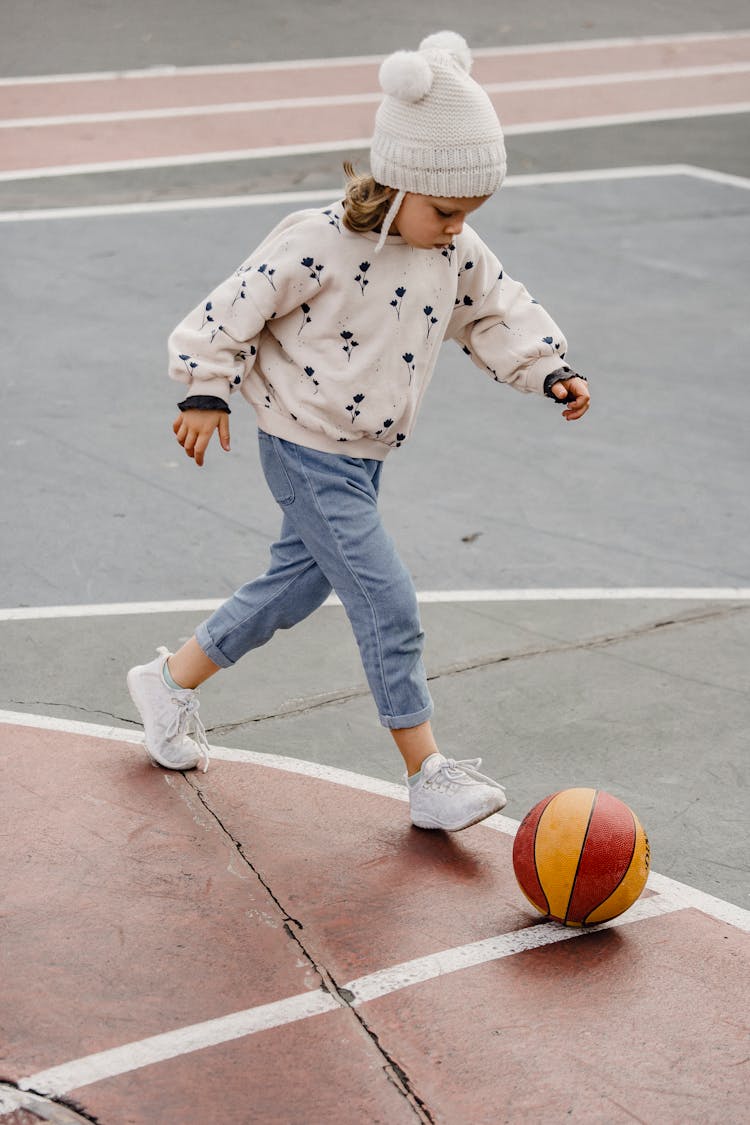 Cute Girl Walking After Ball On Sports Ground