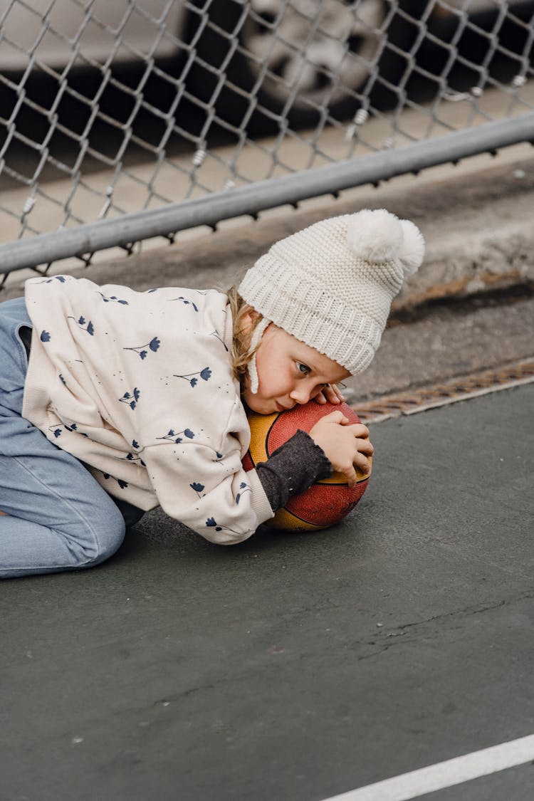 Cute Frustrated Girl With Ball On Playground