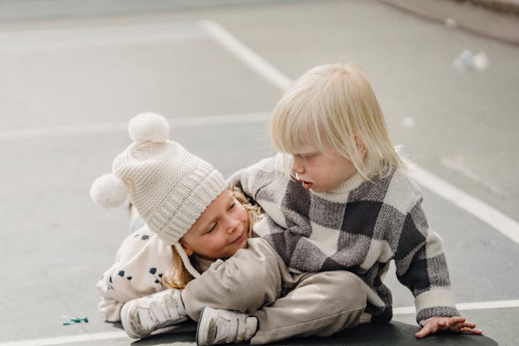 Playful Siblings Hugging On Playground