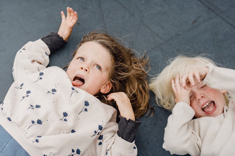 Playful Children Lying On Playground