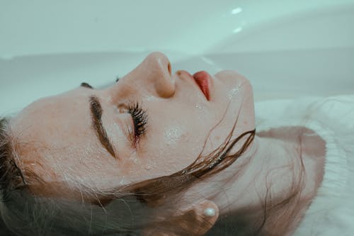 Free Calm woman lying in bathtub in water Stock Photo